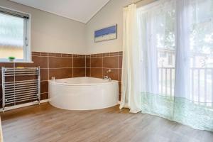 a large bathroom with a tub and a window at Cupid's Lodge in Kingham