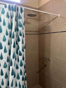 Un baño con ducha con cortina de ducha. en El Descanso del Wayra, en Tilcara