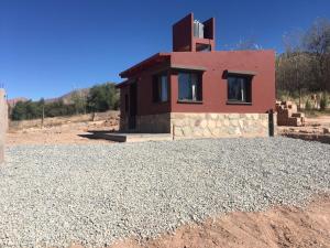 a house in the middle of a field with gravel at El Descanso del Wayra in Tilcara