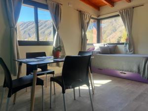 a bedroom with a bed and a table and chairs at El Descanso del Wayra in Tilcara