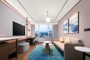 a living room with a couch and a tv at Hilton Garden Inn Handan She County in Handan