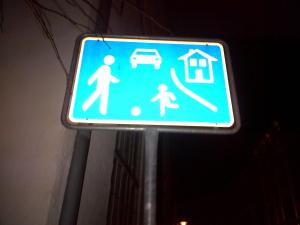 a blue street sign with a family and a house at Kulturdenkmal 60 m2 HISTORISCHES BALKENHÄUSCHEN von 1749 in Lübeck