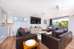 a living room with two leather couches and a table at Magpie Rest in Forster