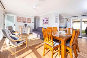 a dining room and living room with a table and chairs at Magpie Rest in Forster