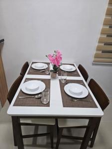 a table with chairs and plates and flowers on it at Kaway Homestay in Butuan