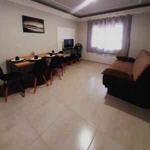 un salon avec un canapé, une table et des chaises dans l'établissement Leandro's Residence, à Balneário Camboriú