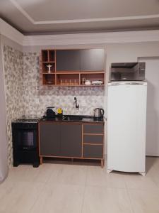 une cuisine avec un réfrigérateur blanc dans une pièce dans l'établissement Leandro's Residence, à Balneário Camboriú