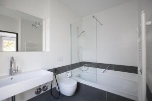 マインツにあるホテル アム ルーマヴェルのバスルーム(洗面台、トイレ、ガラス張りのシャワー付)