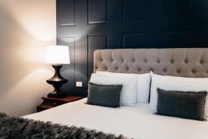 a bedroom with a bed with white pillows and a lamp at de Russie Boutique Hotel in Orange