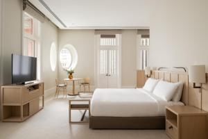 a hotel room with a bed and a television at COMO The Treasury in Perth