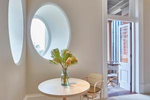a vase with flowers on a table in a room at COMO The Treasury in Perth