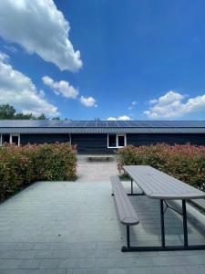 a picnic table and a bench in front of a building at Vakantie huis 4 persoons compleet ingericht in Bladel +4 photos