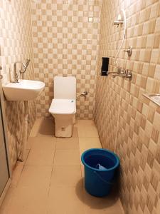 La salle de bains est pourvue de toilettes, d'un lavabo et d'un seau. dans l'établissement Krishna cottage, à Ayodhya