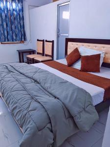 une chambre avec un grand lit avec une grande couverture dans l'établissement Krishna cottage, à Ayodhya