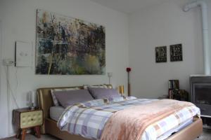 a bedroom with a bed and a painting on the wall at Dolomiti house in Cibiana