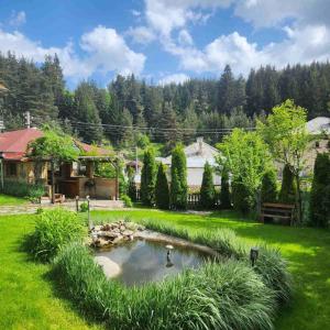 a garden with a pond in the middle of a yard at Guesthouse Classic in Dospat
