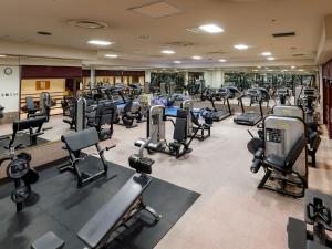 a gym with rows of treadmills and machines at Premier Hotel -Tsubaki- Sapporo in Sapporo