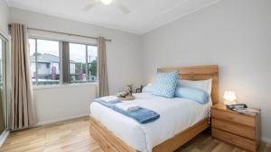 a bedroom with a bed and a large window at Shoal Sanctuary in Nelson Bay