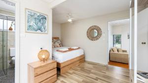 a bedroom with a bed and a mirror at Shoal Sanctuary in Nelson Bay