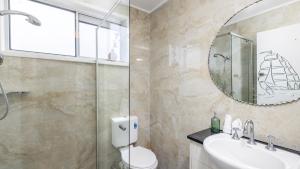 a bathroom with a toilet and a sink and a mirror at Shoal Sanctuary in Nelson Bay