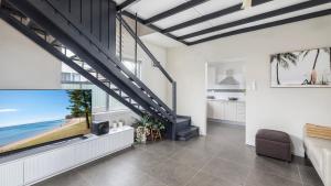 sala de estar con ventana grande y TV en Shoal Sanctuary, en Nelson Bay