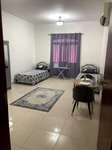 a living room with a bed and a table at Hostel Maral in Mawāliḩ