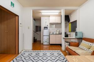 a living room with a couch and a kitchen at Golden House in Tokyo