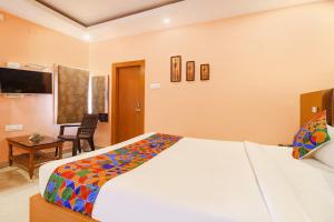 a bedroom with a bed and a desk and a chair at FabHotel Shanti International in Rānchī