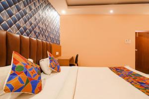 a hotel room with a bed with colorful pillows at FabHotel Shanti International in Rānchī