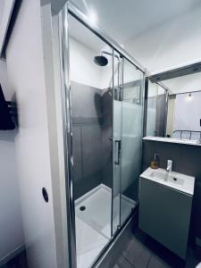 Un baño con ducha de cristal y lavabo. en 7 Rue des Poilus, en La Ciotat