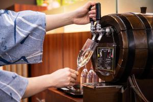 a person pouring a glass of wine into a machine at HAKODATE Uminokaze in Hakodate