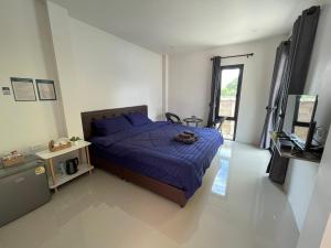 a bedroom with a bed with a blue comforter at Arawan Resort เอราวัณ รีสอร์ท in Ngao