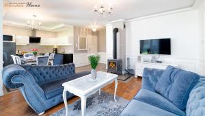 a living room with two blue couches and a table at Wonder Home - Domki górskie z kominkami na kameralnym osiedlu - plac zabaw na terenie kompleksu in Karpacz