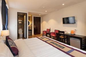 a hotel room with a bed and a table and chairs at Bora Hotel in Sapa