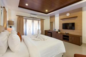 una habitación de hotel con una cama y un televisor en Ami Bendesa Villa - Nusadua, en Nusa Dua