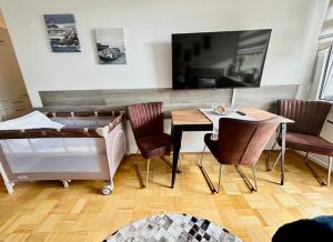 een woonkamer met een tafel, stoelen en een televisie bij Sunset View Apartment with Logia in Ettlingen +21 foto's