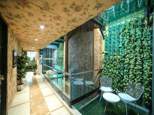 a room with two chairs and a wall with plants at WoodApple Residency in New Delhi