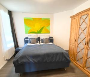 a bedroom with a bed with a painting on the wall at Apartmenthaus Bella Casa in Hagen