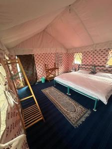 ein Schlafzimmer mit einem Bett in einem Zelt in der Unterkunft Himalyan Wild Trails Premium Swiss Camp Prashar Lake in Mandi + 19 Fotos
