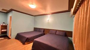 Postel nebo postele na pokoji v ubytování 大潭山莊 Da Tan Mountain INN
