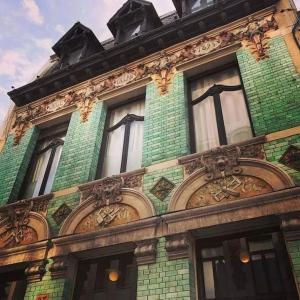 a green brick building with many windows on it at Maison Verte, Monument Historique in Roubaix +28 photos