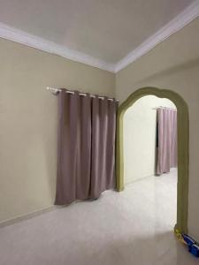 an empty room with a curtain and an archway at Homestay Abah At in Baling +1 photo
