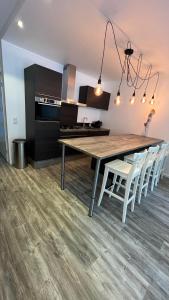 a kitchen with a large wooden table and white chairs at GelreDroom in Arnhem