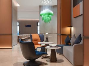 a lobby with chairs and tables and a chandelier at Holiday Inn Express Zhengzhou Garden Road in Zhengzhou