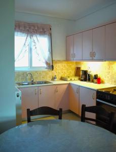a kitchen with a table and a sink and a window at Calma House in Kanálion
