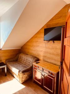 a living room with a couch and a flat screen tv at Oceania Mielno in Mielno