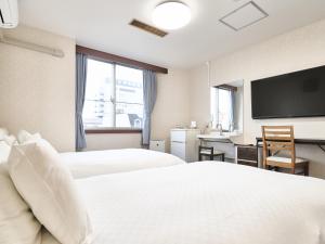 Letto o letti in una camera di Okasan Hotel
