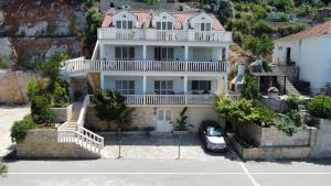 a large white house with a car parked in front of it at Terrace studios with panoramic seaview in Ubli