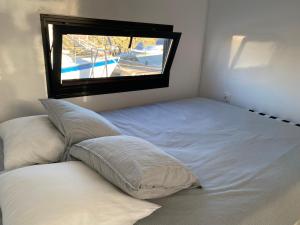 a white bed with a window in a bedroom at Houseboat Cádiz El Puerto - Casa Flotante in El Puerto de Santa María