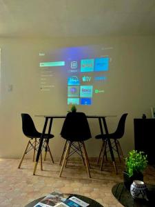 a room with a large screen with a table and chairs at Bonito y acogedor loft en zona céntrica de Puebla in San Baltasar